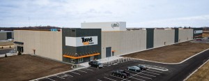 Aerial view of Tuffy\'s exterior showing a large industrial building with a parking lot.