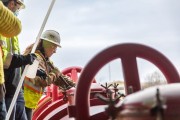 A worker in a hard hat and safety gear operating machinery at an industrial site.