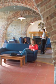 Lounge area featuring blue seating with individuals engaged in conversation and reading.