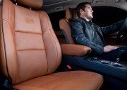 Brown leather car seat with a driver seated in a vehicle\'s interior.