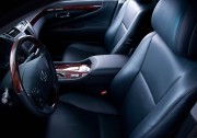 Interior view of a luxury car featuring leather seats and a wooden console.