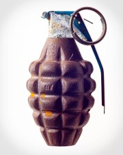 A vintage hand grenade with a textured surface and a safety pin attached to the lever.