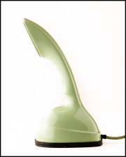 A green vintage telephone with a curved handset and a round base, positioned against a white background.
