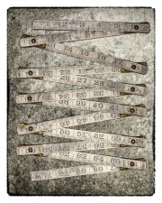 Multiple folding rulers arranged in a flat layout, displaying measurement markings and numbers.